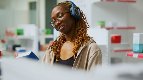 Side view of young woman using mobile phone in office