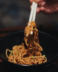 Close-up of person having spaghetti in bowl