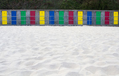Colorful closed doors of huts at sandy beach