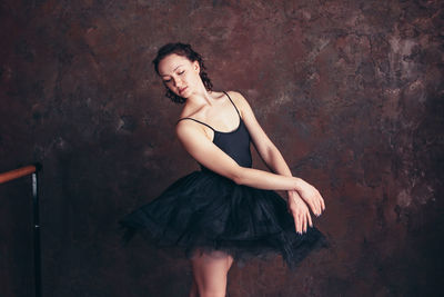Full length of young woman against wall