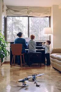 Mother and son playing piano at home