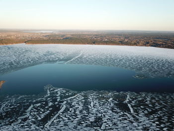 Scenic view of lake against sky during winter