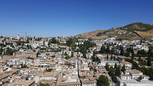 Aerial view of townscape against clear blue sky