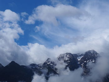 Low angle view of snowcapped mountains against sky