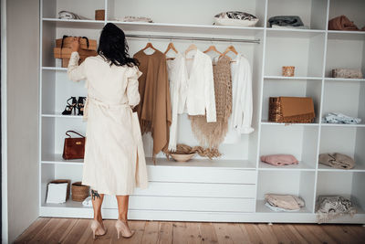 Rear view of woman standing in clothing store