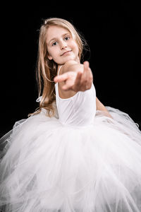 Portrait of beautiful young woman against black background