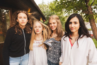 Portrait of happy teenage girls standing at yard