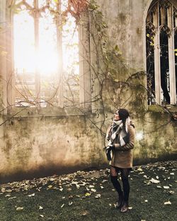 Full length of woman standing by abandoned building