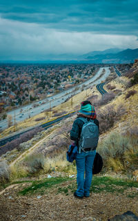 Rear view of man looking at mountains against sky