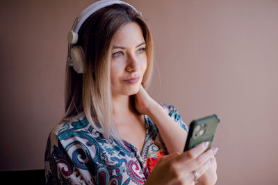 Portrait of young woman using mobile phone at home