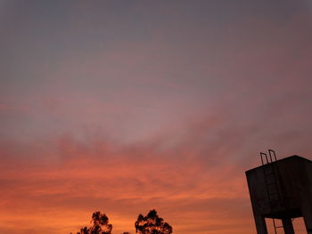 Low angle view of water tower against sky during sunset