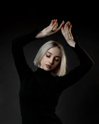 Woman standing against black background