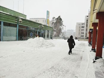 Rear view of man walking in snow