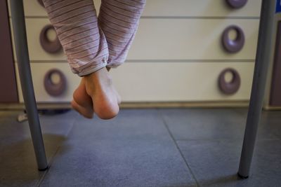 Low section of woman jumping on bed