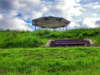 Scenic view of grassy field against cloudy sky