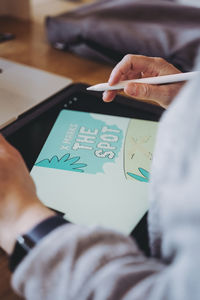 Midsection of woman using digital tablet