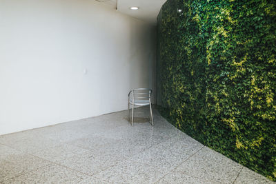 Empty chair and table against wall
