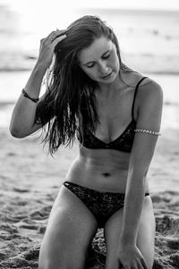 Young woman smiling while standing at beach