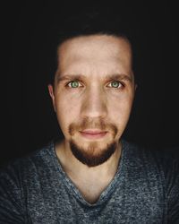 Close-up portrait of young man in darkroom