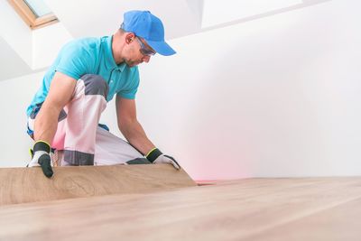 Low angle view of man arranging planks on floor