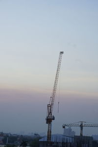 Cranes at construction site against sky