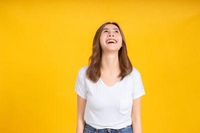 Portrait of a beautiful young woman over yellow background