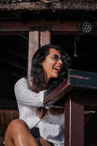 Happy woman looking away while sitting at outdoors cafe