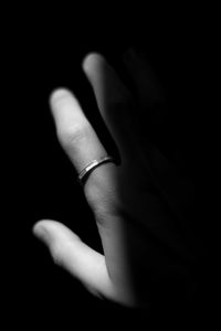 Close-up of human hand against black background