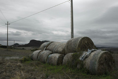 Hay bales on field against sky