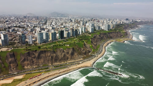 High angle view of buildings by sea against sky
