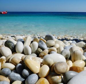 Close-up of pebbles on beach against sky