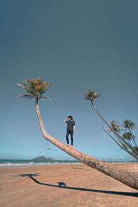 Full length of man on beach against clear sky