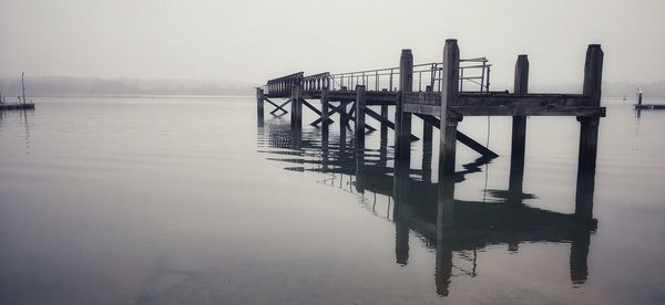 Pier on lake against sky