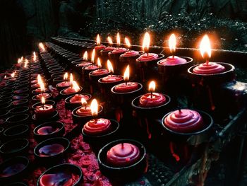 Close-up of illuminated tea light candles in temple