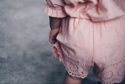 Midsection of woman holding pink while standing outdoors