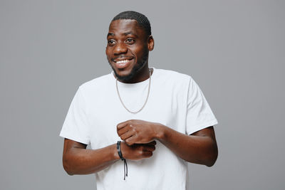 Portrait of young man standing against black background
