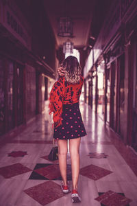 Full length rear view of woman walking in hotel lobby