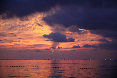 Scenic view of sea against cloudy sky during sunset