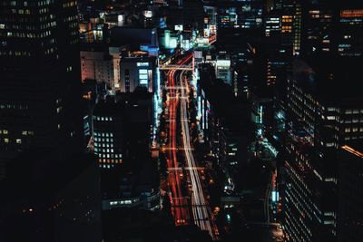 High angle view of light trails on road in illuminated city at night