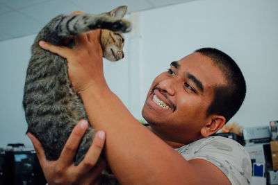 Side view of man holding cat