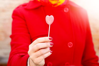 Midsection of woman holding lollipop