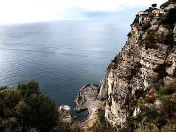 Scenic view of cliff by sea against sky