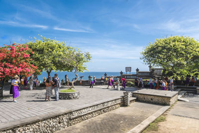 Group of people standing by the tree against sky