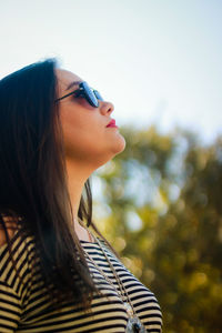 Close-up of woman in sunglasses against sky