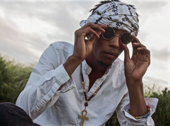 Close-up of young man wearing sunglasses against sky