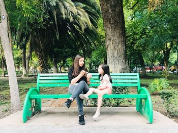 Woman sitting on bench in park