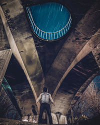 Low angle view of man standing under bridge