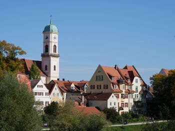 Church amidst buildings against blue sky