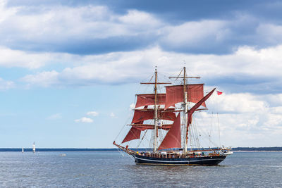 Sailboat sailing on sea against sky