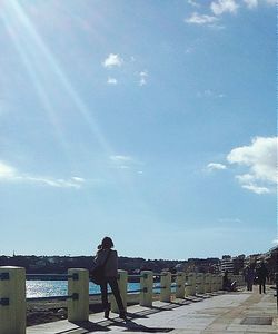 Woman standing against blue sky